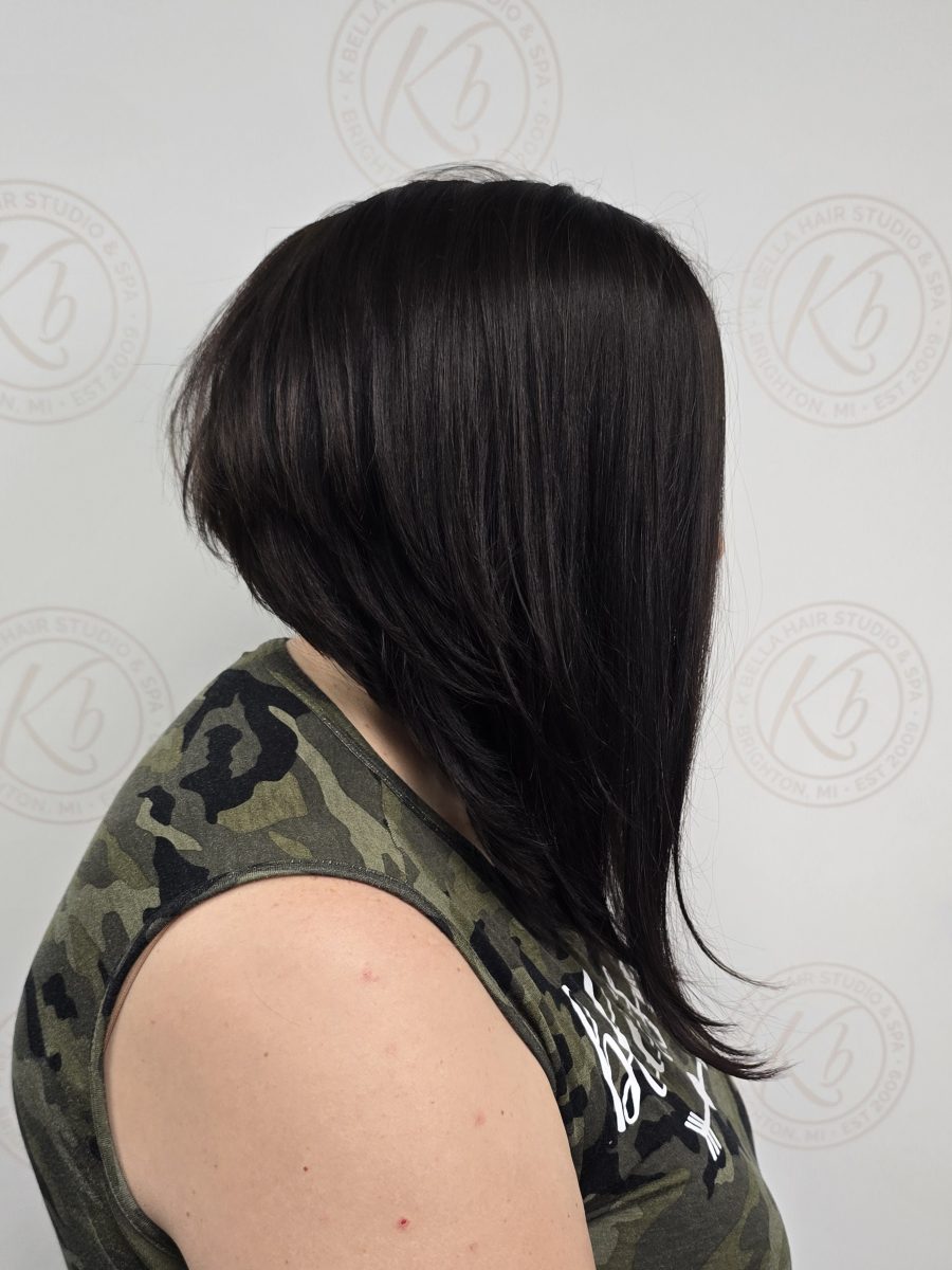 Three-quarter rear view of angled bob showing layered texture and depth of chocolate brown color, by Kristan Sayers at K Bella Hair Studio & Spa in Brighton, MI
