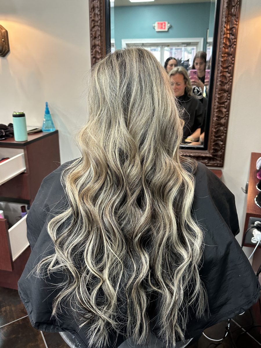 Back view of long wavy hair with seamlessly blended dimensional color after keratin extension installation by Liberty Greenwood at K Bella Hair Studio & Spa in Brighton, MI