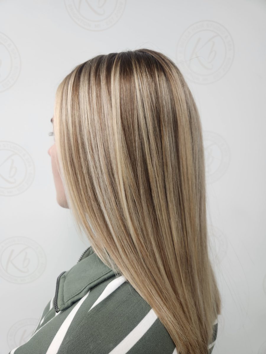 Back view of long layered hair with balayage highlights in warm and cool tones, styled straight by Siobhan Rozinski at K Bella Hair Studio & Spa in Brighton, MI