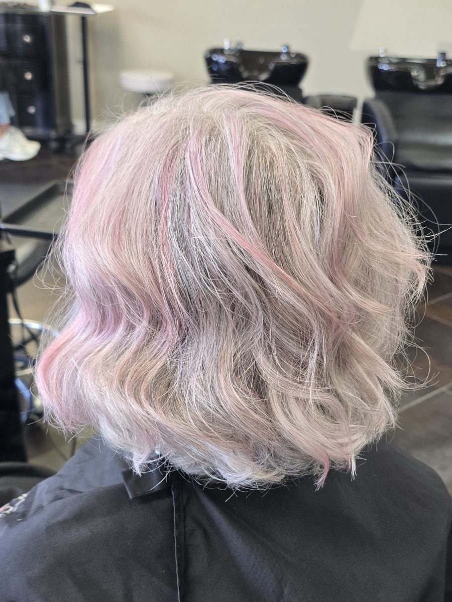 Back view of a short layered bob with pink and blonde balayage, styled with soft waves by Kristan Sayers at K Bella Hair Studio & Spa in Brighton, MI