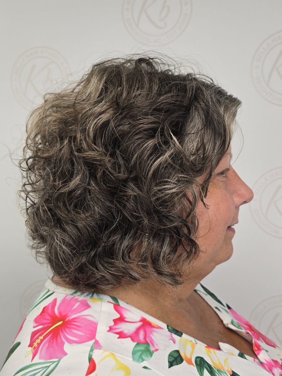 Side profile of layered curly hair with defined texture and movement, styled by Kristan Sayers at K Bella Hair Studio & Spa in Brighton, MI