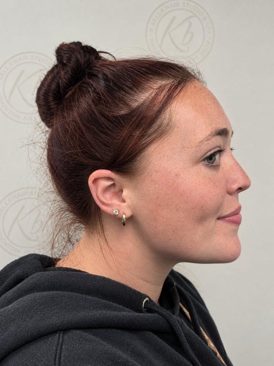 Profile view of a client showing a second lobe piercing, newly placed in the lower lobe by Paige Spence at K Bella Hair Studio & Spa in Brighton, MI