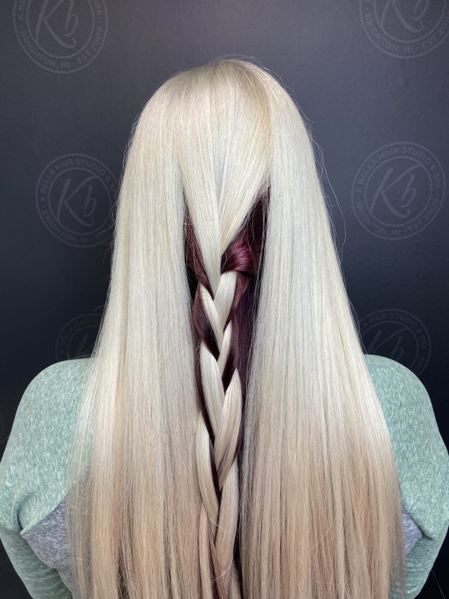 Rear view of long hair with a braided section revealing deep purple tones throughout by Kameryn Bell at K Bella Hair Studio & Spa in Brighton, MI