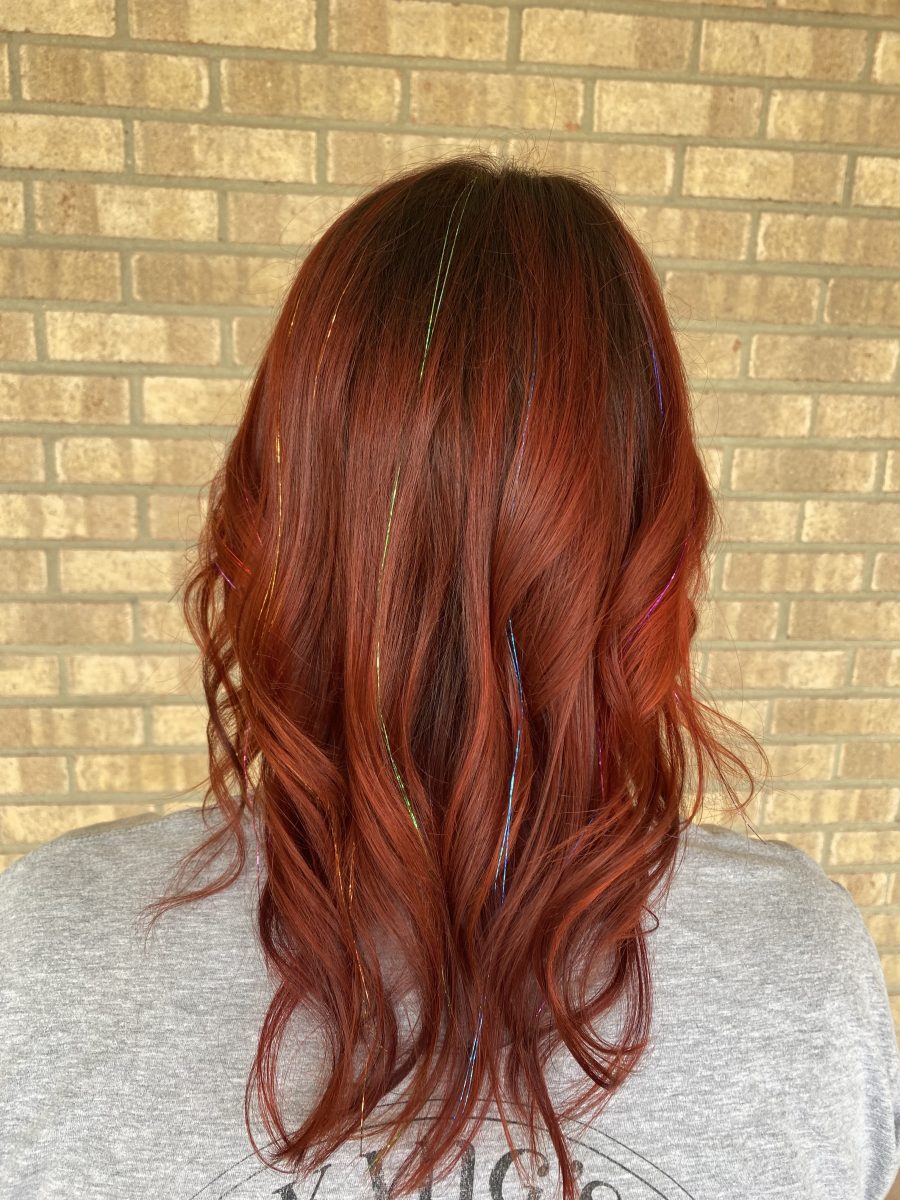 Back view of long wavy copper-toned hair with tinsel detail visible in the strands by Allison Bowsher at K Bella Hair Studio & Spa in Brighton, MI