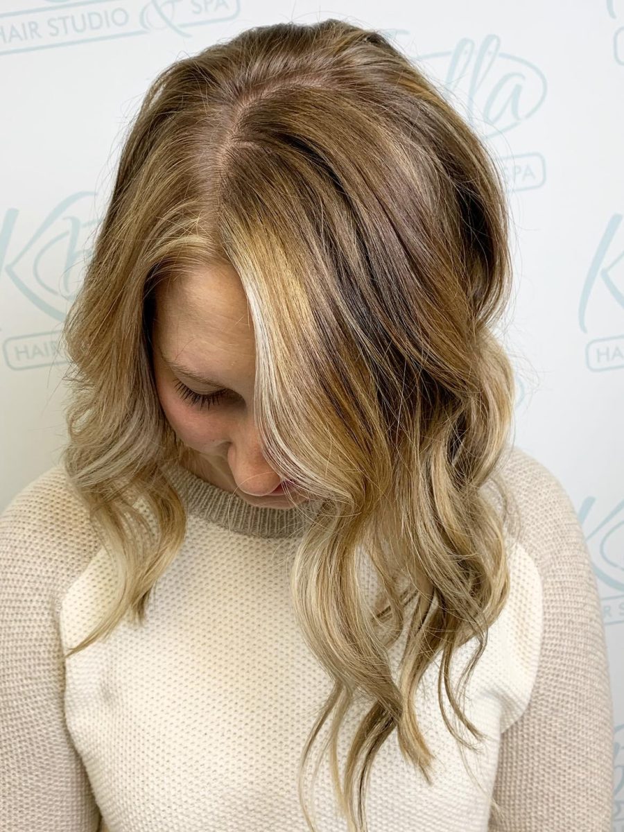 Side view of shoulder-length blonde hair with balayage highlights concentrated toward the ends and soft waves framing the face by Brittney Holstege at K Bella Hair Studio & Spa in Brighton, MI