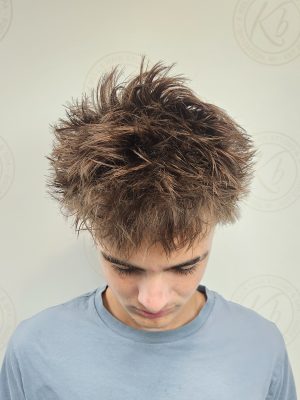 Front view of a textured men's crop with voluminous, tousled top and faded sides by Siobhan Rozinski at K Bella Hair Studio & Spa in Brighton, MI