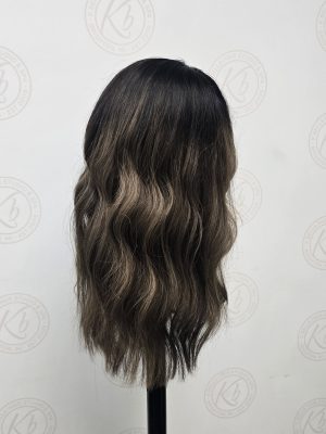 Long dark brunette wig with caramel and chocolate balayage highlights, soft layers, and subtle waves, displayed on a stand by Kristan Sayers at K Bella Hair Studio & Spa in Brighton, MI