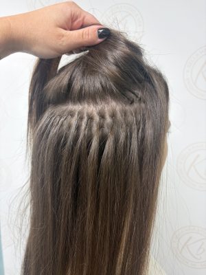 Close-up of brown hair with keratin fusion extensions blended into the natural roots, shown from behind by Abbey French at K Bella Hair Studio & Spa in Brighton, MI